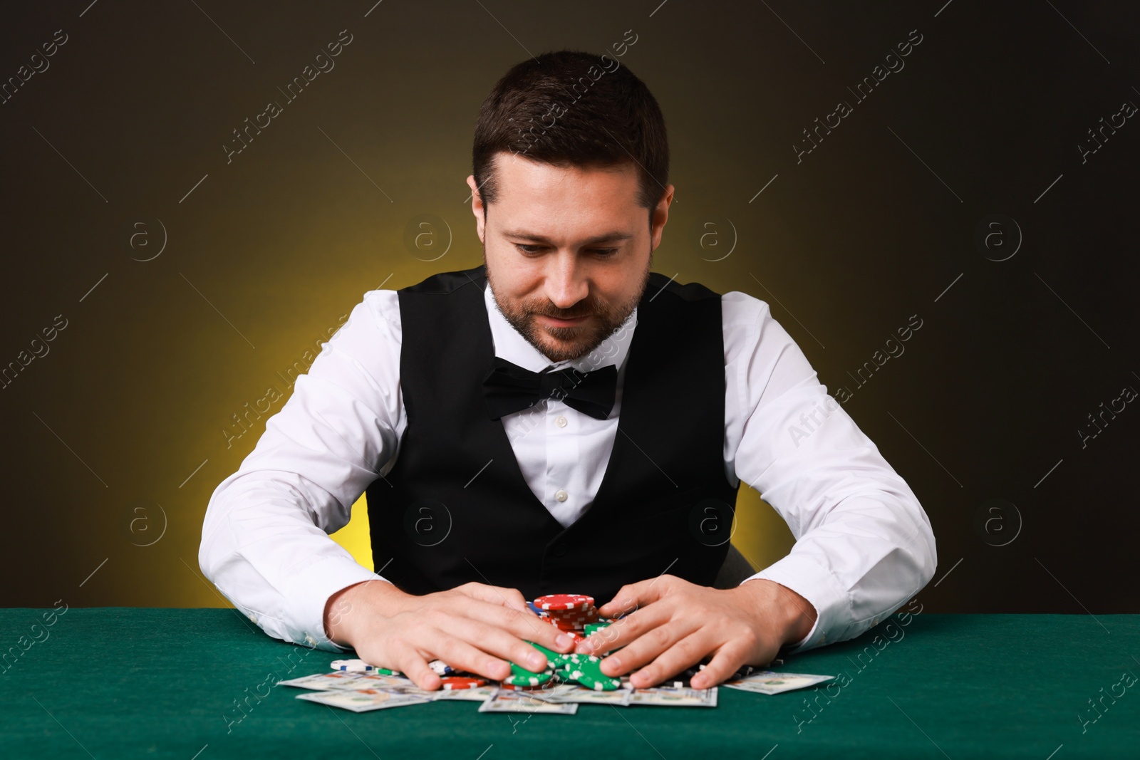 Photo of Professional croupier accepting bets at gambling table