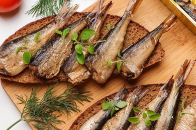 Photo of Delicious sandwiches with sprats and dill on table, top view