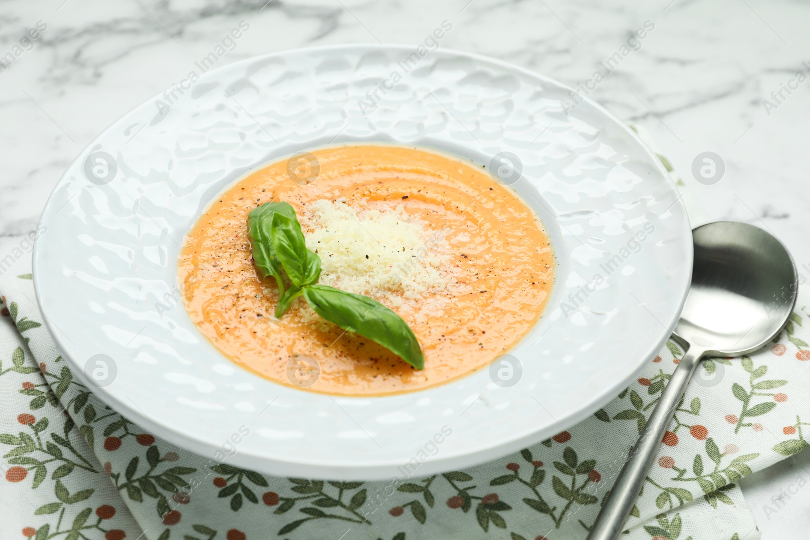 Photo of Delicious sweet potato soup served on white marble table, closeup