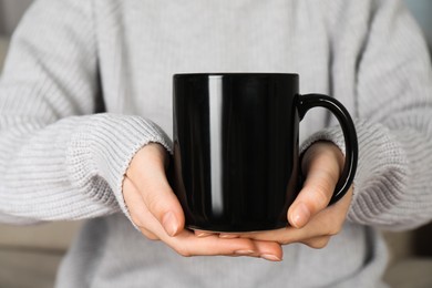 Photo of Woman with black ceramic cup, closeup. Mockup for design