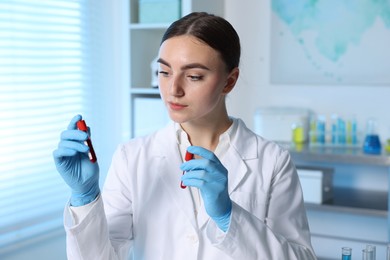 Photo of Laboratory testing. Doctor holding test tubes with blood samples indoors