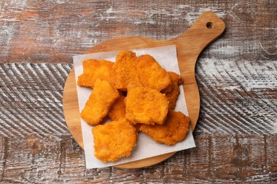 Photo of Delicious chicken nuggets on wooden table, top view