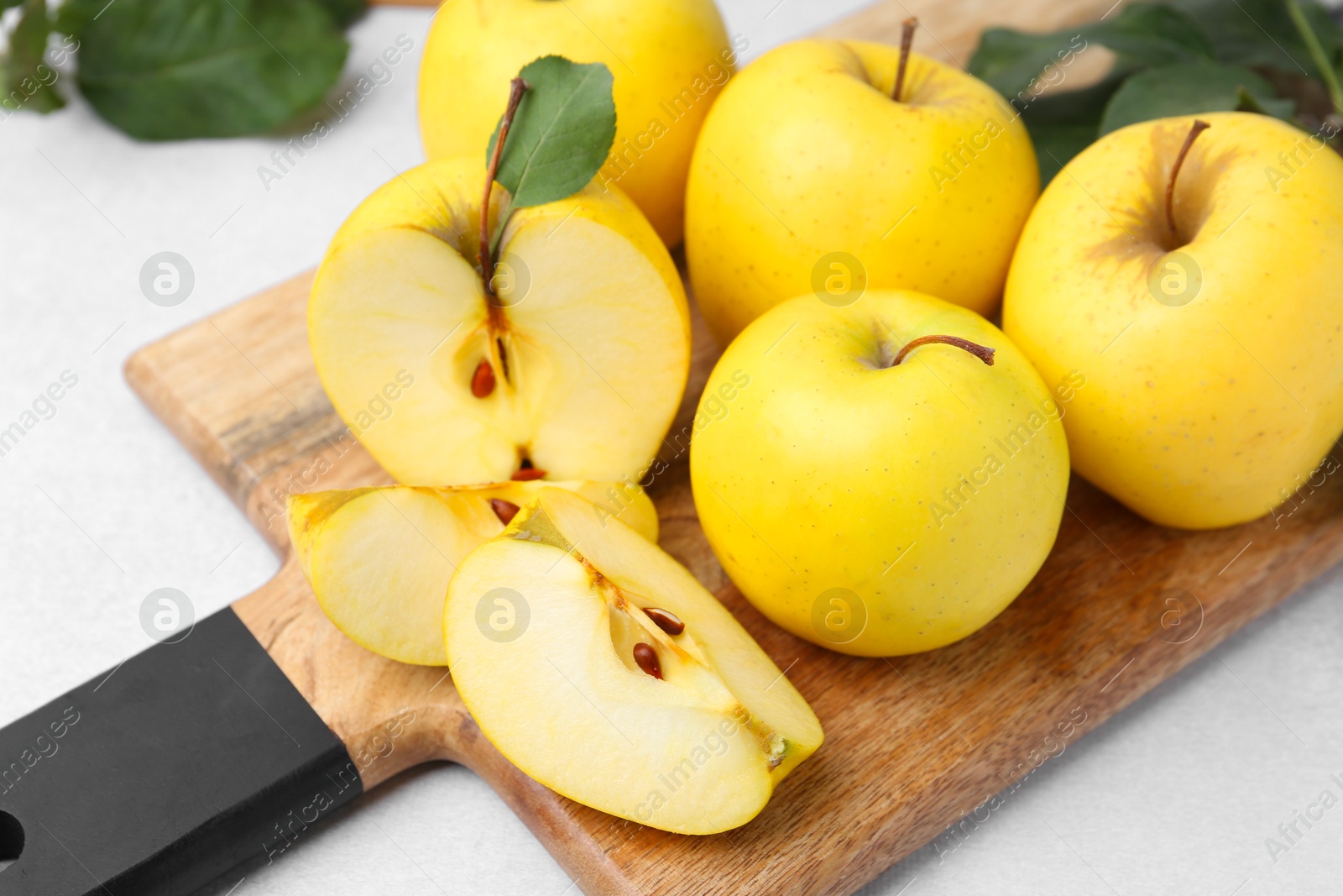 Photo of Ripe yellow apples on light grey table, closeup