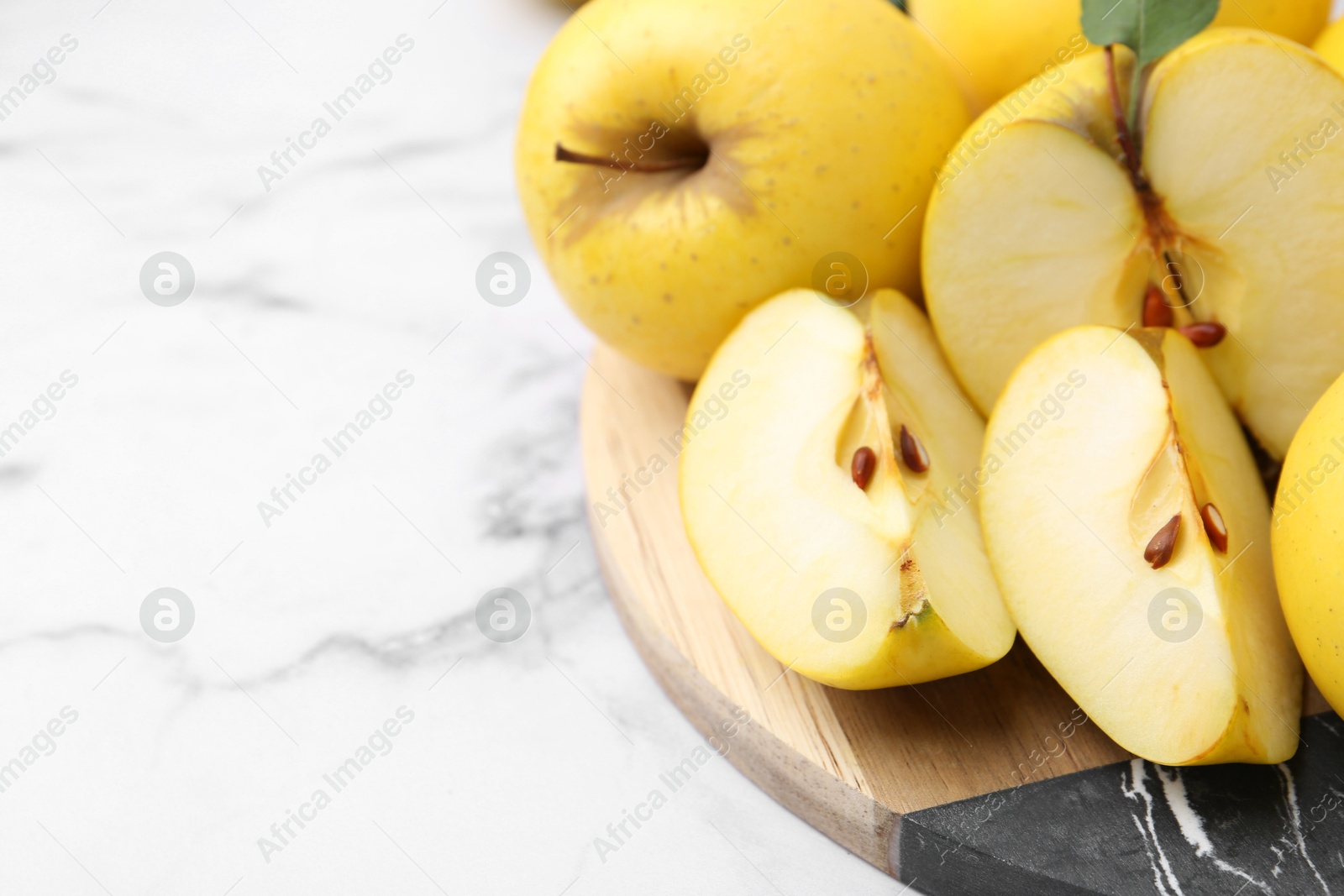 Photo of Ripe yellow apples on white marble table, closeup. Space for text