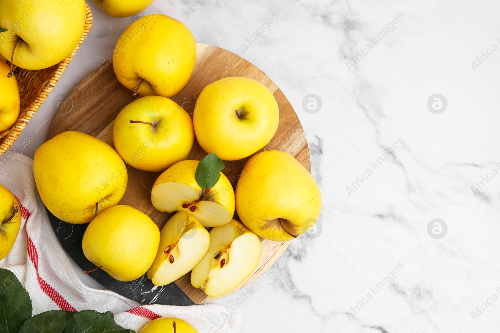 Photo of Ripe yellow apples on white marble table, top view. Space for text