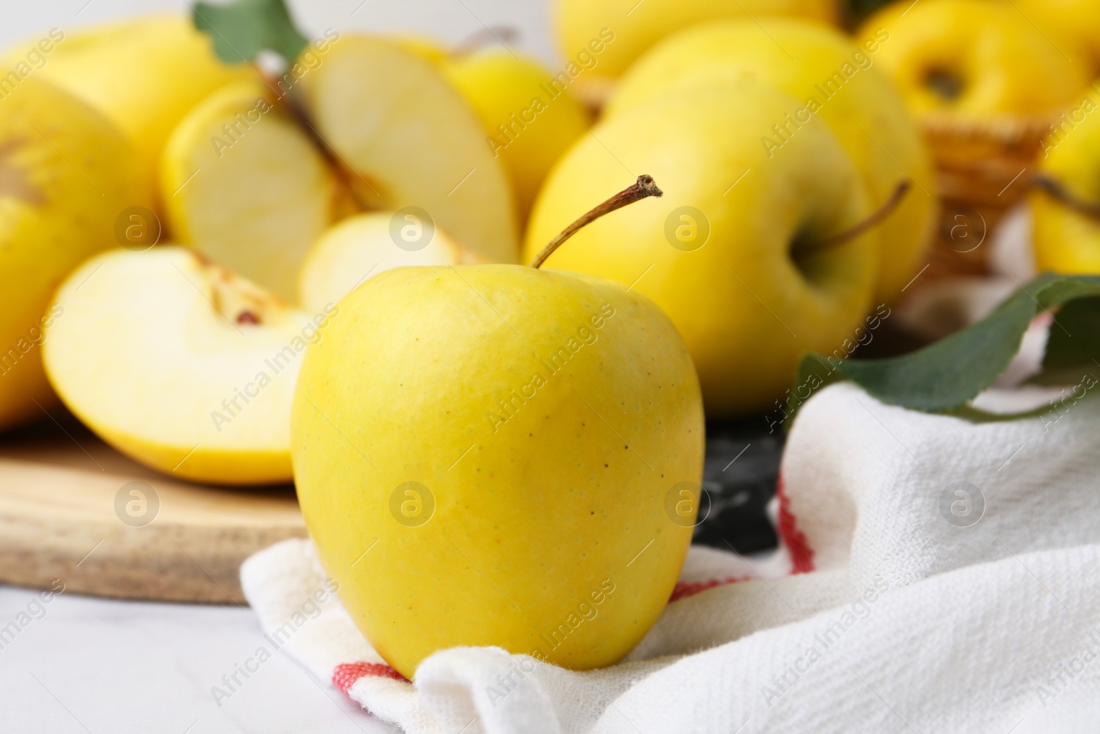 Photo of Whole and cut ripe yellow apples on table, closeup