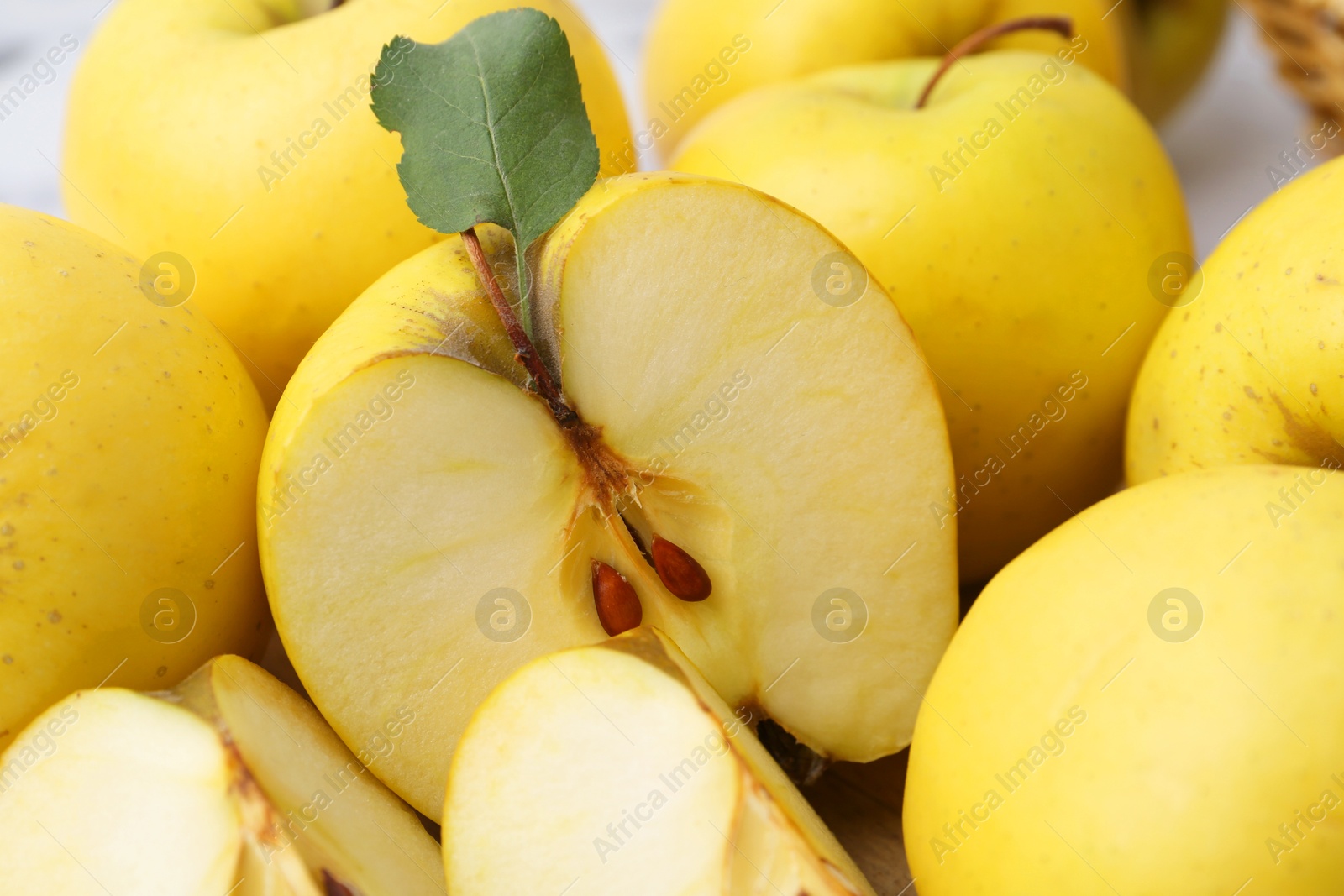 Photo of Whole and cut ripe yellow apples on table, closeup