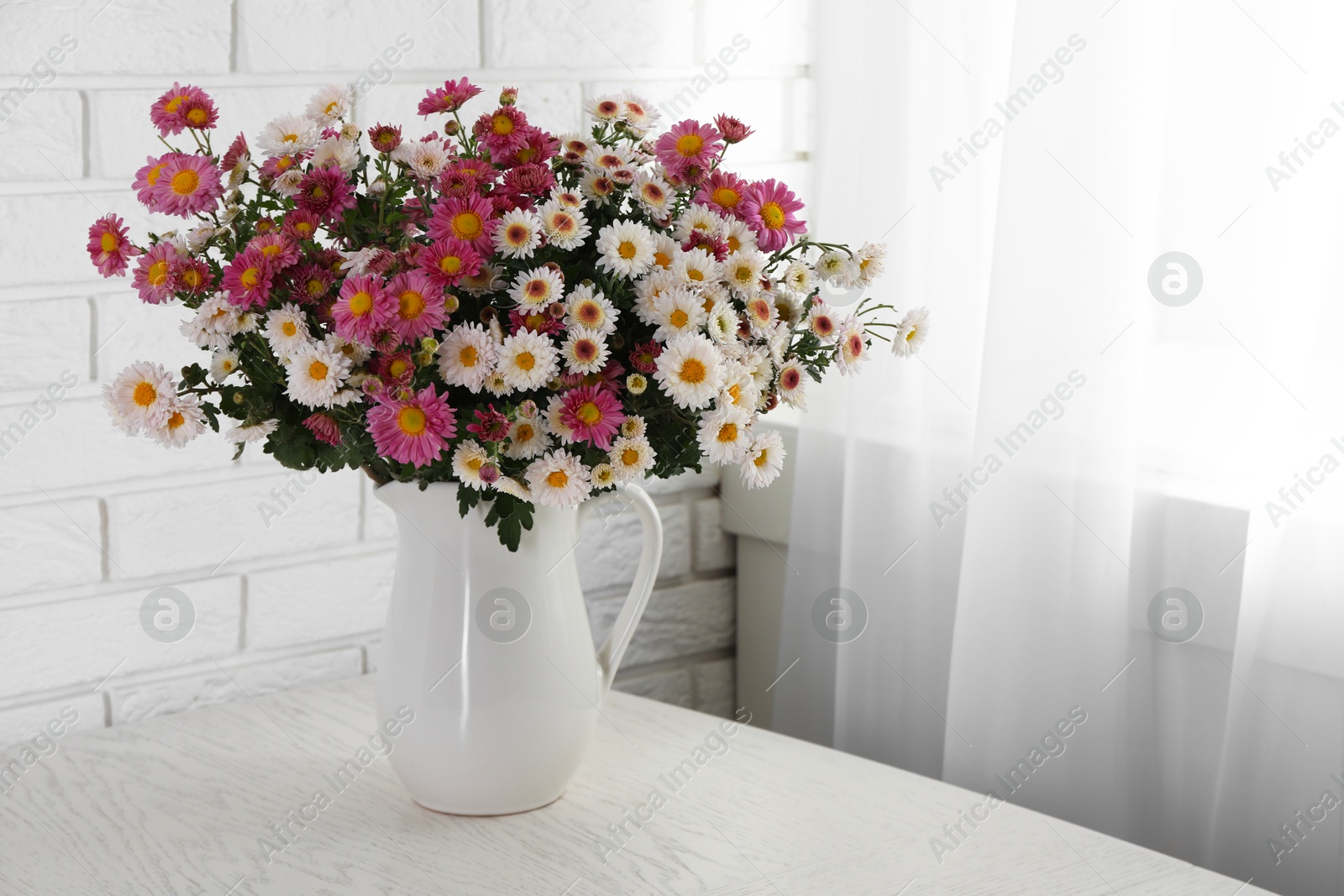 Photo of Vase with beautiful flowers on white wooden table. Space for text