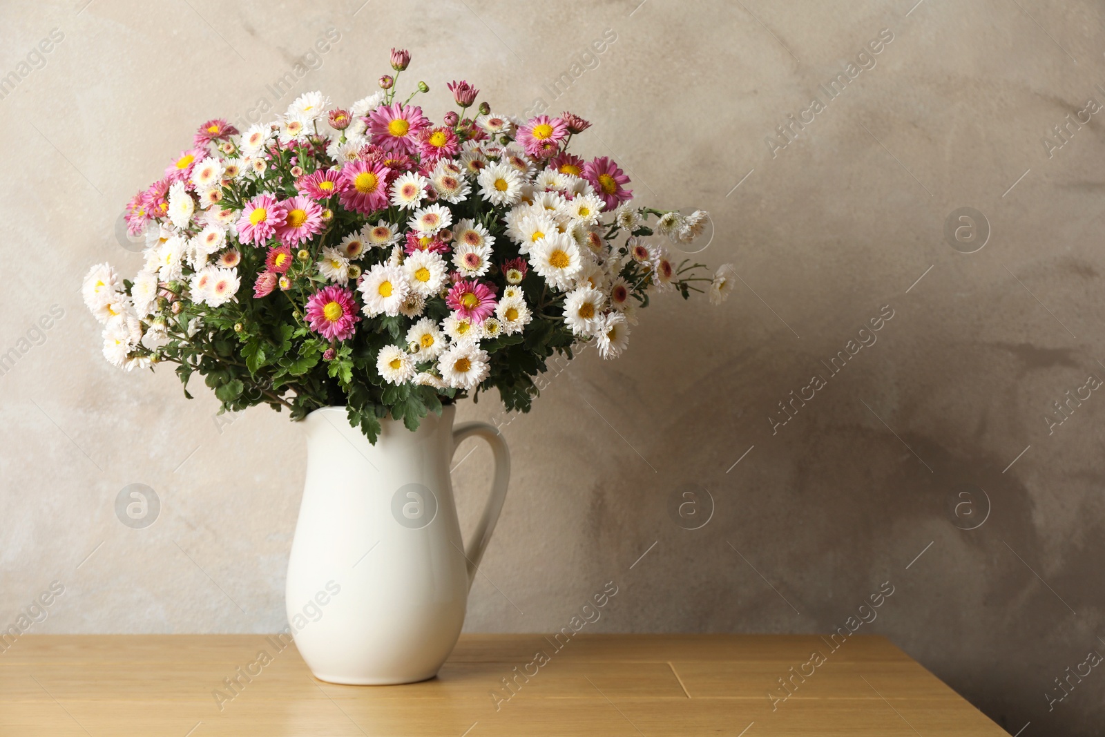 Photo of Vase with beautiful flowers on pink wooden table. Space for text