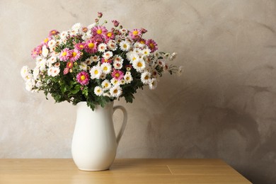 Photo of Vase with beautiful flowers on pink wooden table. Space for text