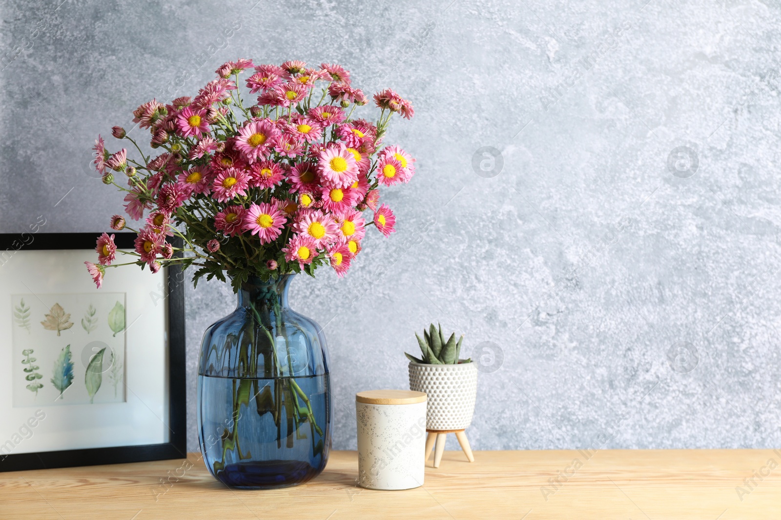 Photo of Beautiful flowers in vase and decor on wooden table. Space for text