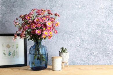 Photo of Beautiful flowers in vase and decor on wooden table. Space for text