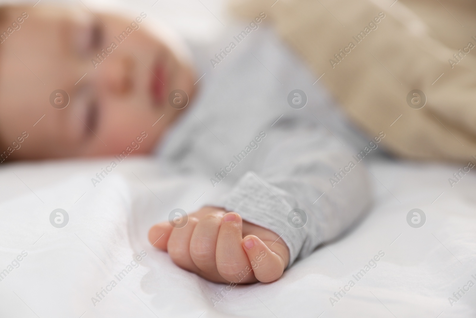 Photo of Cute little baby sleeping on bed at home, selective focus