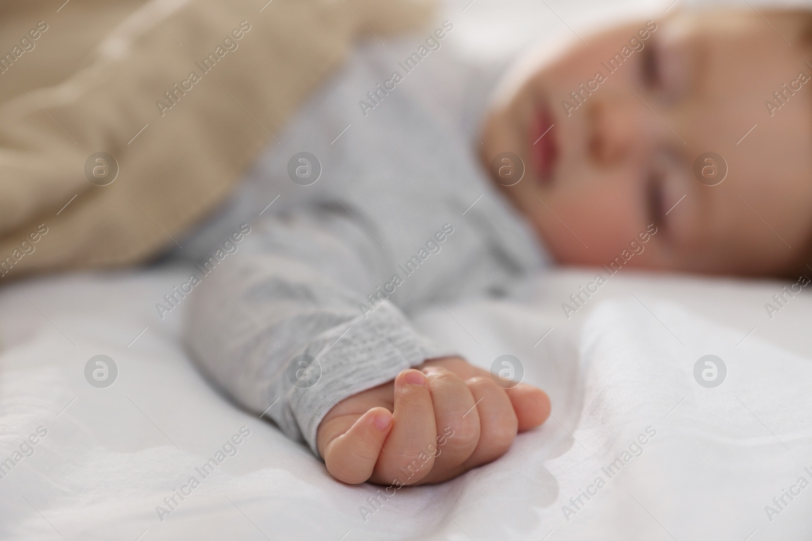 Photo of Cute little baby sleeping on bed at home, selective focus