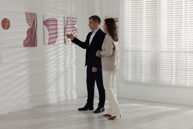 Photo of Woman and man studying beautiful artwork in gallery