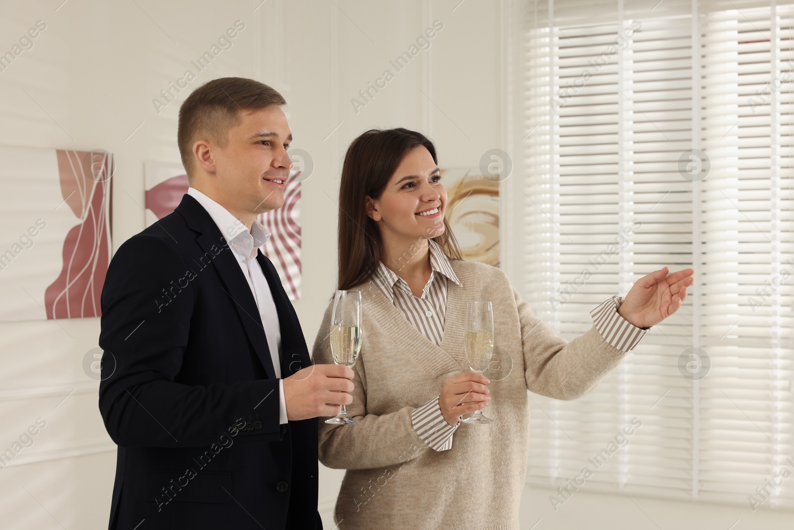 Photo of Couple enjoying art and sparkling wine in gallery