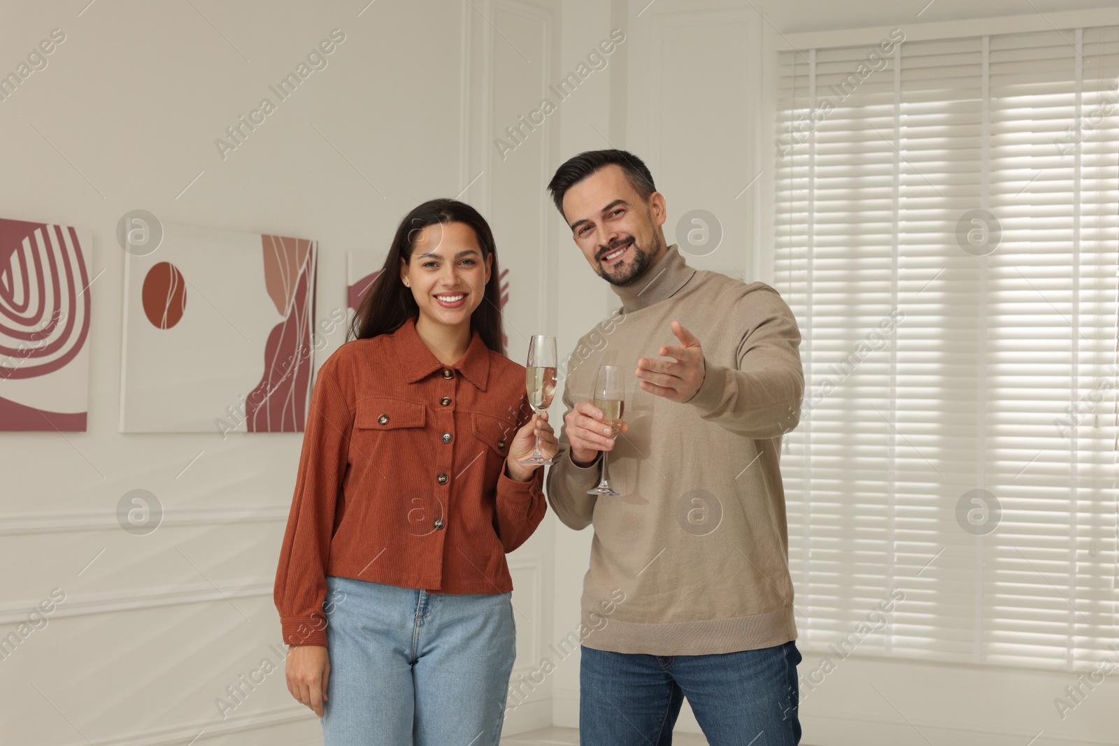 Photo of Couple enjoying art and sparkling wine in gallery