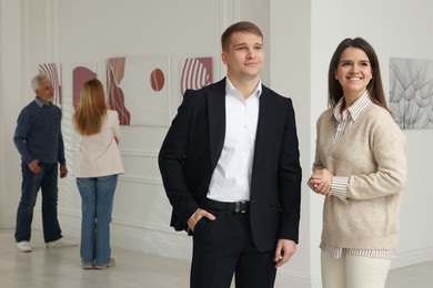 Happy woman and man visiting art gallery