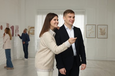 Photo of Happy woman and man visiting art gallery