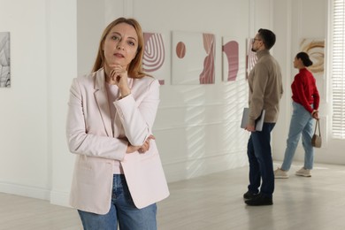 Beautiful woman enjoying art in modern gallery