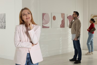 Photo of Beautiful woman enjoying art in modern gallery