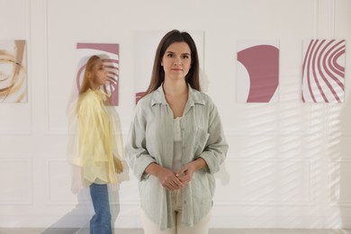 Woman in art gallery and people passing by, motion blur effect