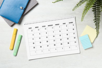 Photo of Timetable. Monthly planner and stationery on white wooden table, flat lay