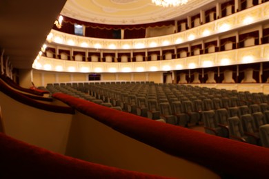 Photo of Rows of gray comfortable seats in theatre, selective focus