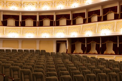 Rows of gray comfortable seats in theatre