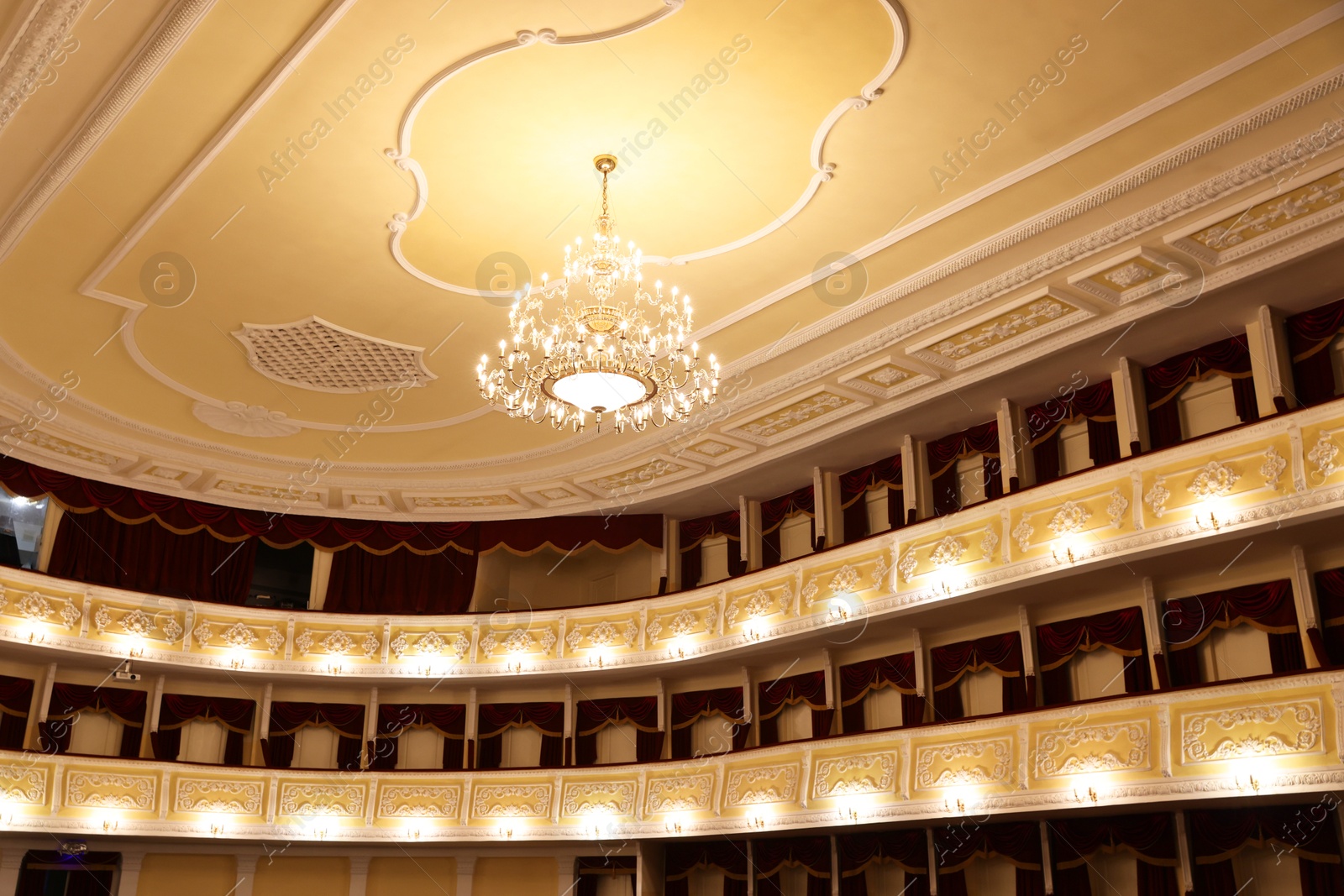 Photo of Stylish vintage chandelier in theatre, low angle view