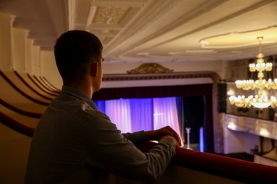 Photo of Young man watching theatrical performance in theatre