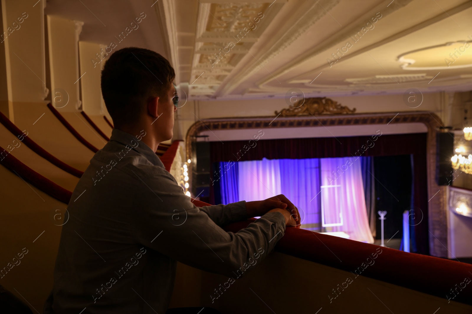 Photo of Young man watching theatrical performance in theatre