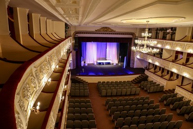 Theatre interior with stage, rows of comfortable seats and beautiful chandelier