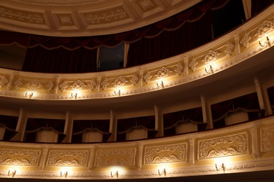 Photo of Balconies with vintage wall lamps and projector in theatre