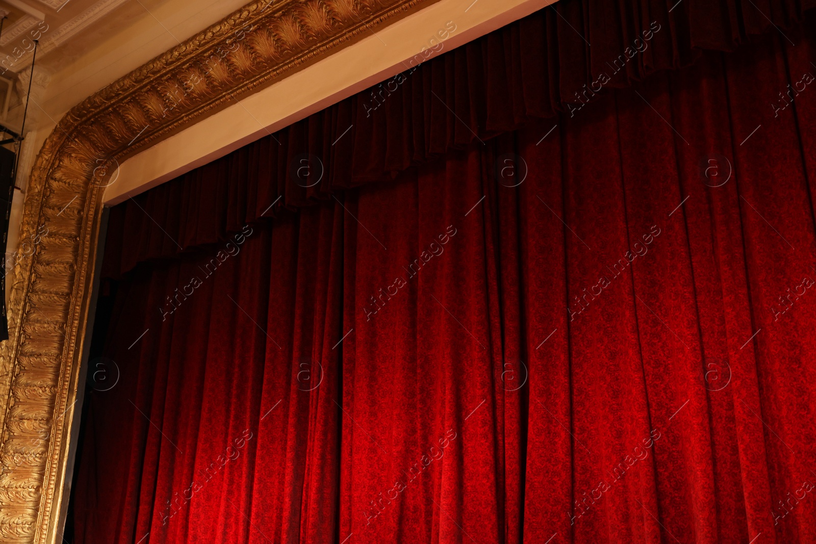 Photo of Elegant red curtains in theatre, low angle view