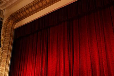 Photo of Elegant red curtains in theatre, low angle view