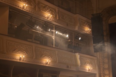 Photo of Professional spotlights and smoke in theatre, low angle view