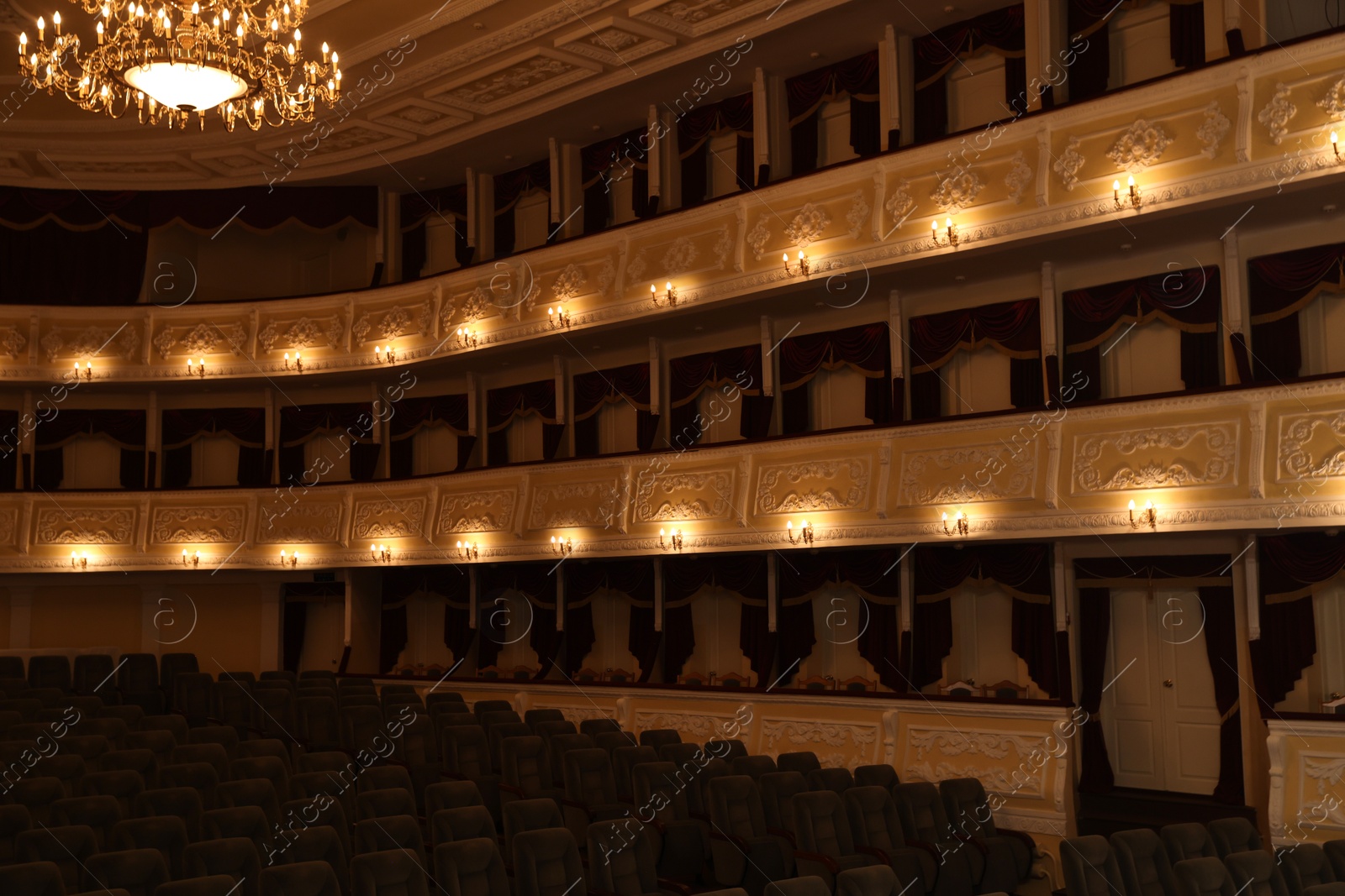 Photo of Rows of comfortable seats and beautiful chandelier in theatre