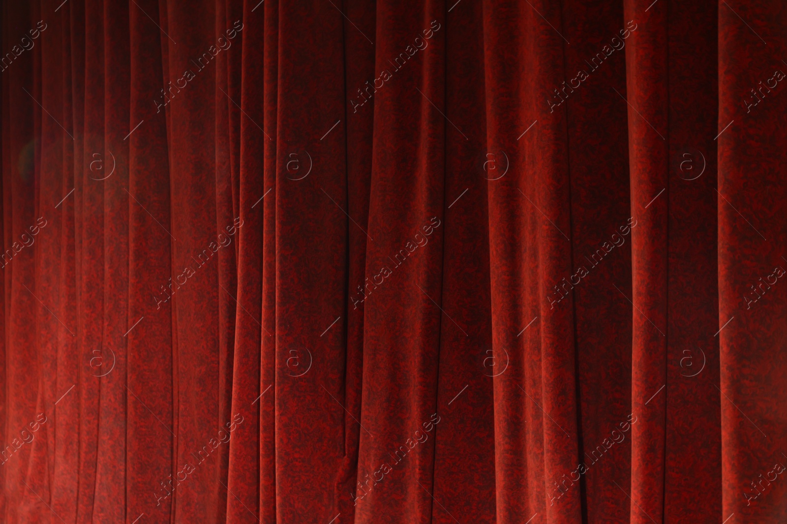 Photo of Elegant red curtains in theatre as background, closeup