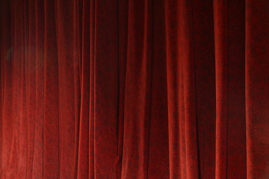 Photo of Elegant red curtains in theatre as background, closeup