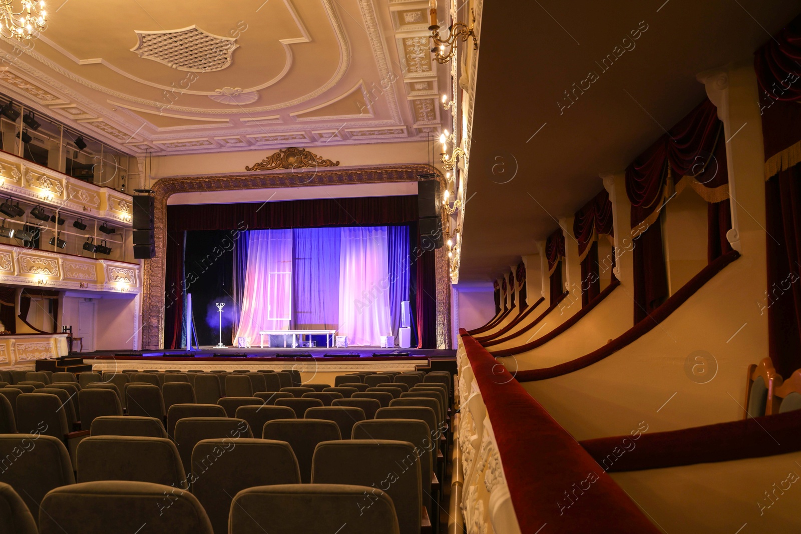 Photo of Theatre interior with stage, rows of comfortable seats and beautiful chandelier