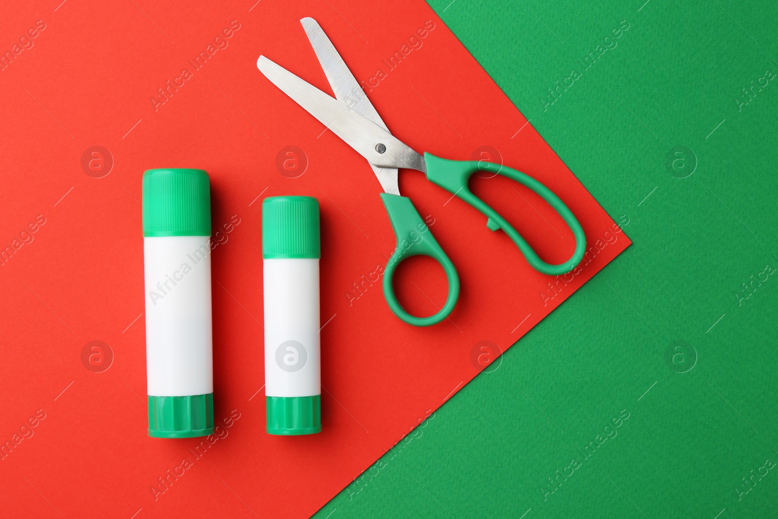 Photo of Glue and scissors on color background, flat lay