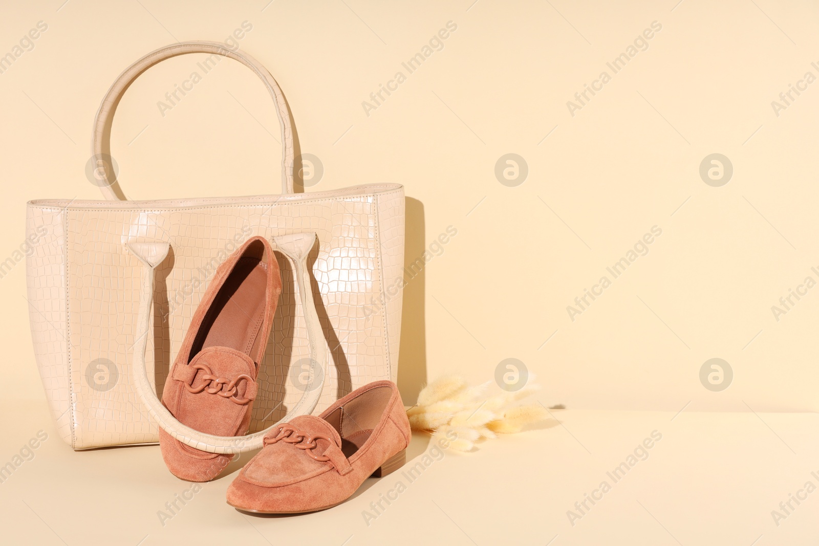 Photo of Bag and shoes on beige background, space for text