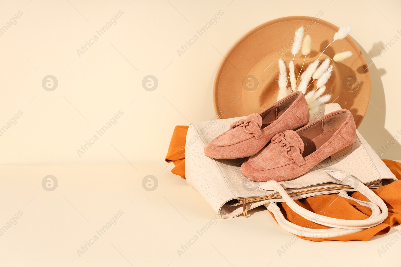 Photo of Clothes, shoes and bag on beige background, space for text