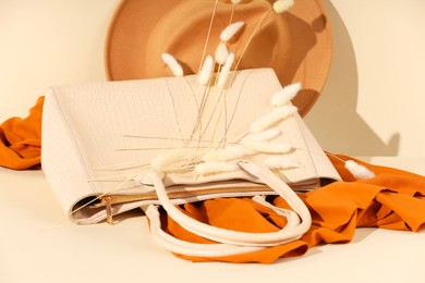 Photo of Clothes, hat and bag on beige background