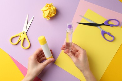 Photo of Woman with glue, scissors and colorful paper at table, top view