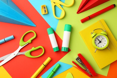 Photo of Flat lay composition with glue, scissors and other stationery on color background