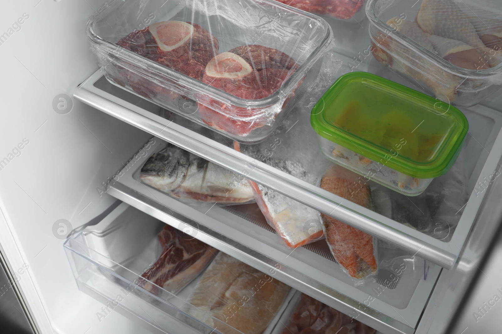 Photo of Different frozen meat and fish products in fridge, closeup