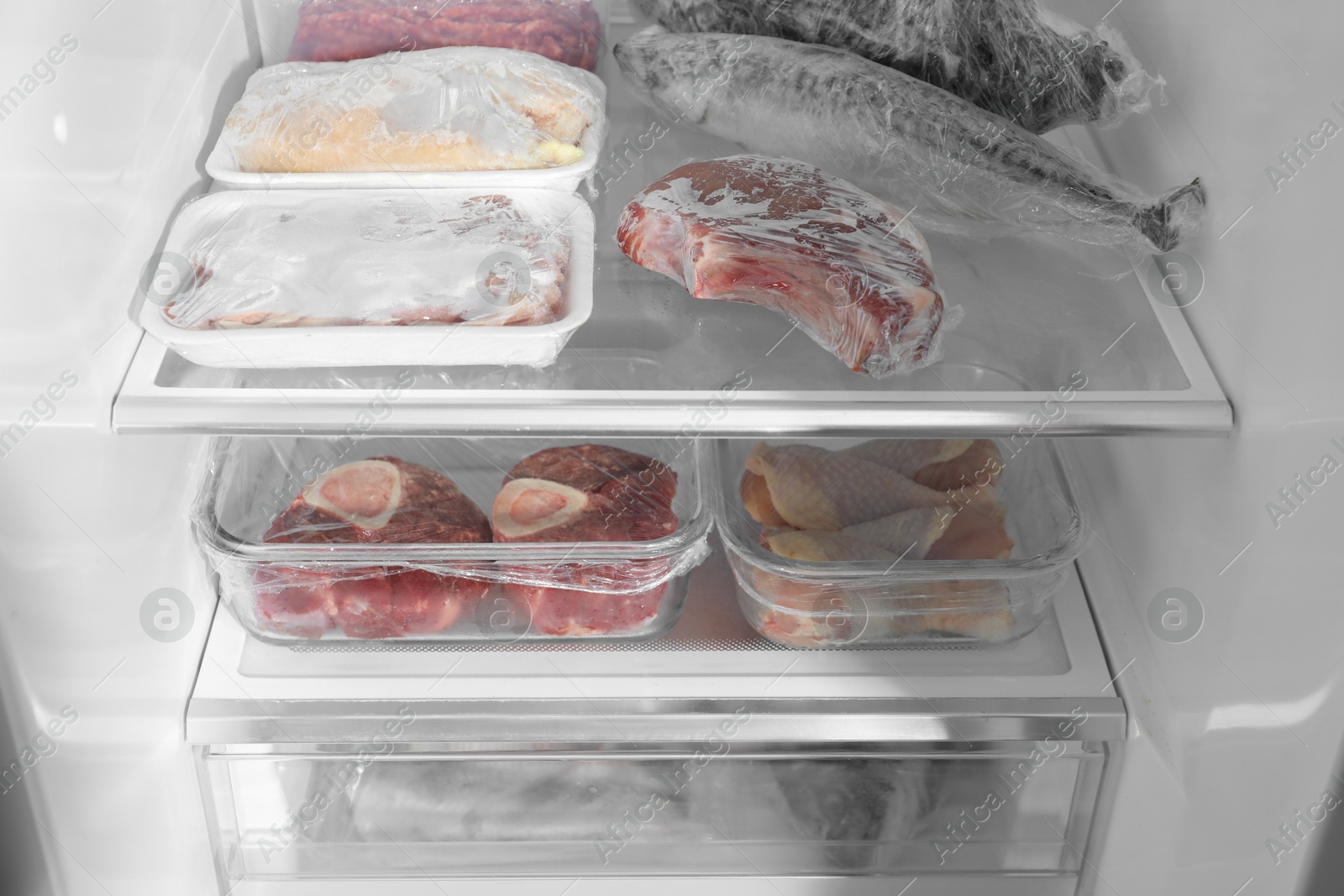 Photo of Different frozen meat and fish products in fridge, closeup