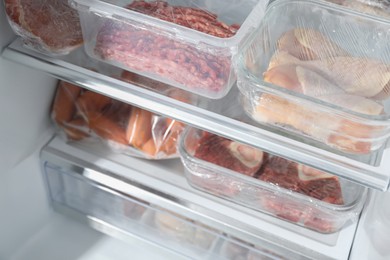 Photo of Different frozen meat products in fridge, closeup